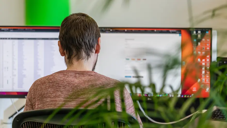 Sander aan het werk achter een monitor