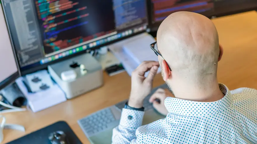 Mark die aan het werk is achter een monitor